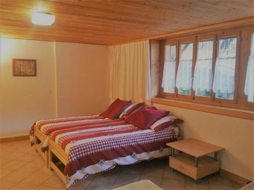 a bedroom with a bed and a window at Tambour 4 in Rossinière