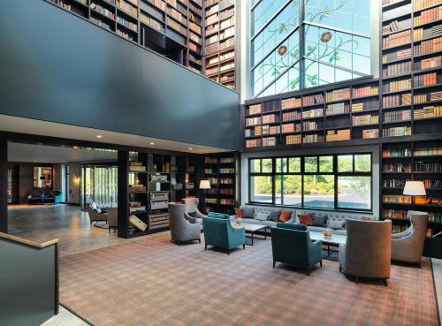 a library with couches and chairs and books at The Dunloe Hotel & Gardens in Killarney