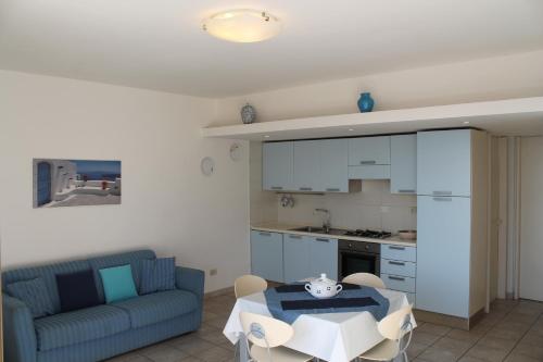 a living room with a table and a blue couch at Cala Gavetta 5 in La Maddalena