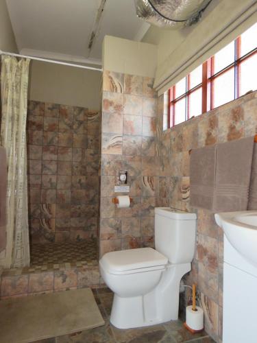 a bathroom with a toilet and a sink at Riverside Manor in Nottingham Road