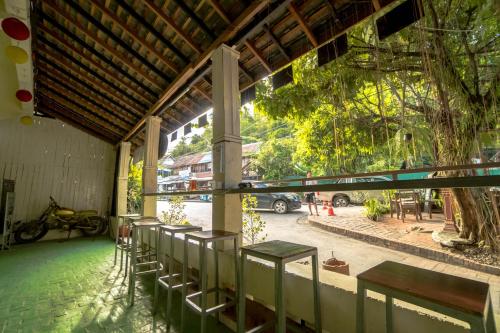 a row of benches in a building with a tree at Y Not Laos Hostel in Luang Prabang