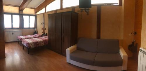 a room with a couch and a bed and a chair at Hotel La Pigna in Bardonecchia