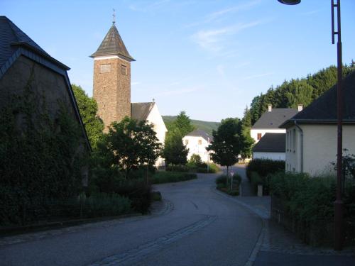 an empty street with a clock tower in a village at Apartment " Welwerwoltz " in Wilwerwiltz
