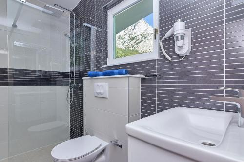 a bathroom with a white toilet and a sink at Holiday home Sergio in Bast