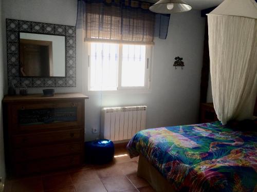 Un dormitorio con una cama, una cómoda y un espejo. en El encanto de la Isleta con WI-FI, en La Isleta del Moro