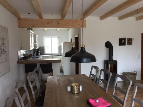 una cucina e una sala da pranzo con tavolo e sedie in legno di Hof Vilmnitz Haus B a Putbus