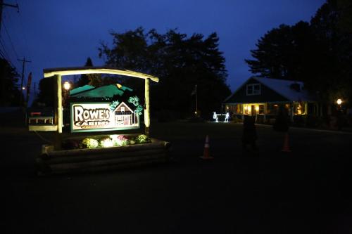a house sign in the middle of a street at night at Rowe's Adirondack Cabins of Schroon Lake in Schroon Lake
