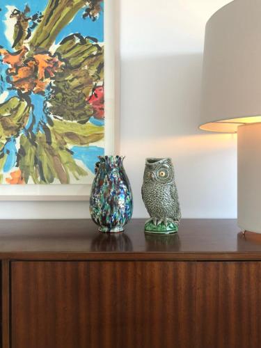 two vases sitting on top of a wooden table with a painting at LUXURY ALVOR PENTHOUSE in Alvor