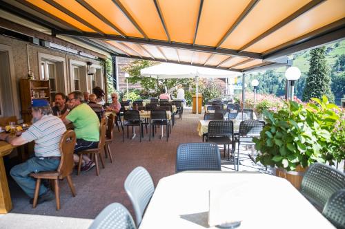 un grupo de personas sentadas en mesas en un restaurante en Gästehaus Schäfli, en Intschi