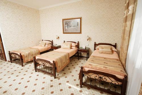 a bedroom with three beds in a room at Hotel Asia Khiva in Khiva