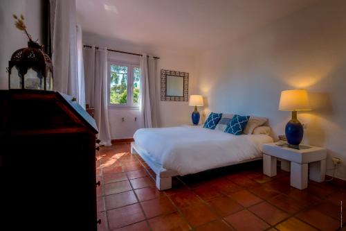 ein Schlafzimmer mit einem Bett mit blauen Kissen und einem Fenster in der Unterkunft Villa Pájaro en Tarifa con vistas a ÁFRICA in El Bujeo