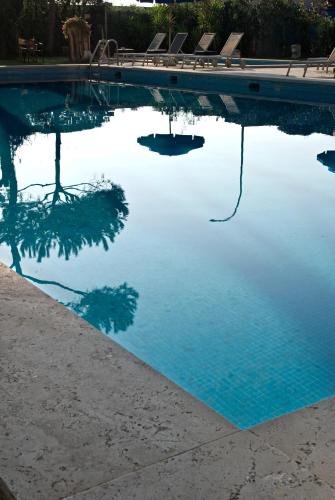 a pool of blue water with chairs in it at Versilia Palace Hotel in Marina di Pietrasanta