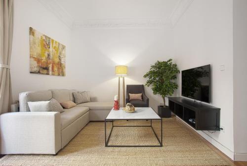 a living room with a couch and a table at Genteel Home Chamberí in Madrid