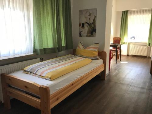 łóżko w pokoju z zielonymi zasłonami w obiekcie Pension Nordlicht w mieście Norddeich
