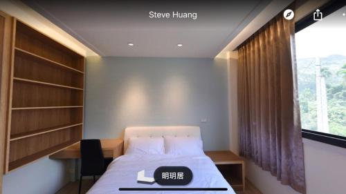 a bedroom with a bed and a desk and a window at Ming Yueju in Guoxing
