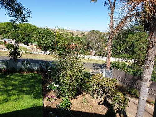 a yard with a fence and some plants and trees at The Haven: Make our Home your Home in Estcourt