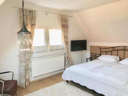a bedroom with a bed and a tv and a window at Ferienhaus Strandgut in Zingst