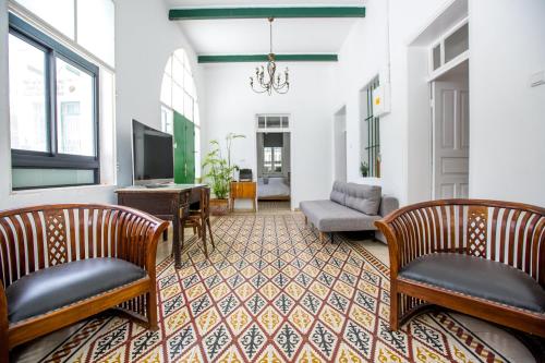 a living room with two chairs and a tv at Berenice Winery Hotel in Tiberias