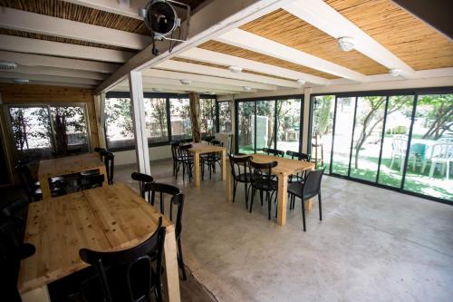 a dining room with tables and chairs and windows at Berenice Winery Hotel in Tiberias