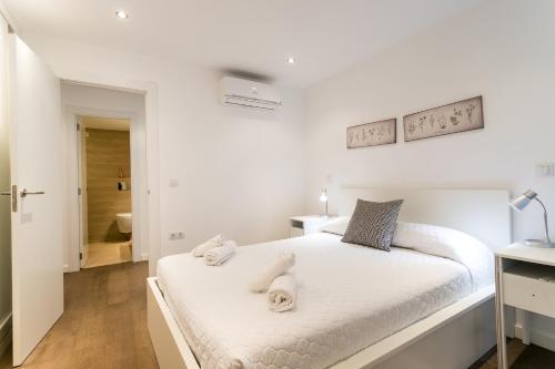 バレンシアにあるApartUP Botánicoのベッドルーム1室(白いベッド1台、タオル付)