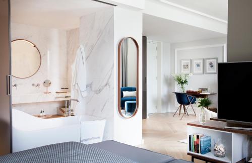 a bedroom with a bathroom with a tub and a mirror at Lasala Plaza Hotel - Adults Only in Donostia-San Sebastián