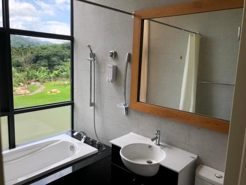 a bathroom with a sink and a mirror at Ming Yueju in Guoxing