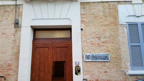 eine Holztür an einem Gebäude mit einem Schild darauf in der Unterkunft B&B Domvs tva in Chieti