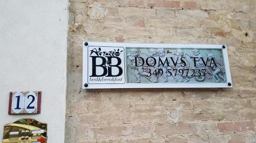 a sign on the side of a brick wall at B&B Domvs tva in Chieti