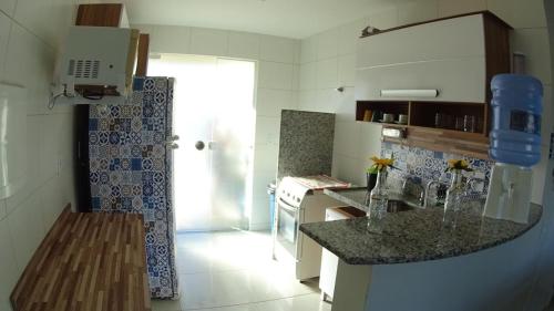 a kitchen with a counter top in a room at Apartamento Condomínio Villa das Águas in Praia do Saco