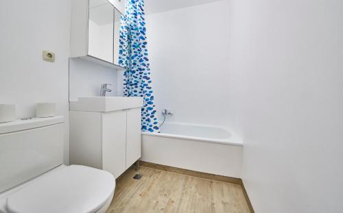 La salle de bains blanche est pourvue de toilettes et d'un lavabo. dans l'établissement Appartement Comfy, à Saalbach-Hinterglemm