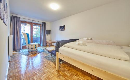 a bedroom with a bed and a desk and a window at Appartement Comfy in Saalbach Hinterglemm
