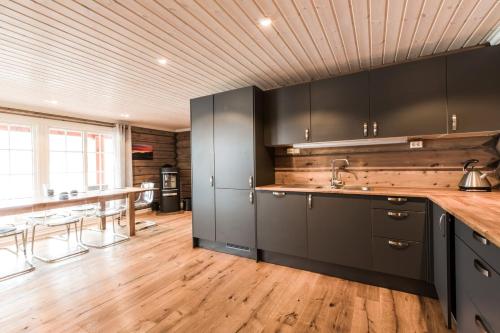 BrunstadにあるLake View Apartment 4 bedroomsの黒いキャビネット付きのウッドフロアのキッチン