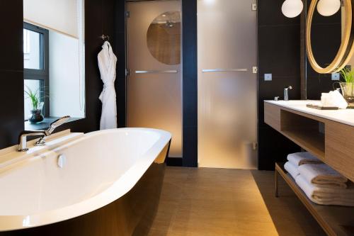 uma casa de banho com uma grande banheira branca e 2 lavatórios em Le Cinq Codet em Paris
