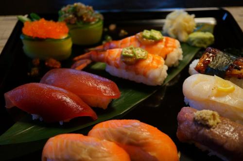 a plate of sushi with shrimp and other foods at Atelier Bee's Knees Bed & Breakfast in Ikuma