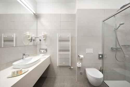 a bathroom with a toilet and a sink and a shower at Hotel Salona Palace in Solin