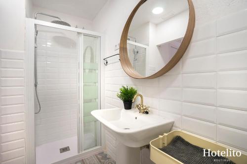 Baño blanco con lavabo y espejo en Hotelito Boutique Cinca, en Hospitalet de Llobregat
