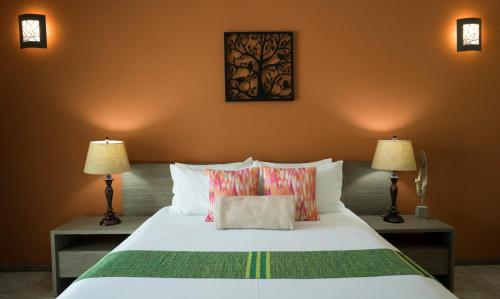 a bedroom with a large white bed with two lamps at Costa Esmeralda Village in Palm-Eagle Beach