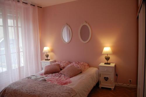 モンタルジにあるMagnifique T3 hyper centre ville Montargisのベッドルーム1室(ランプ2つ、鏡2つ付)