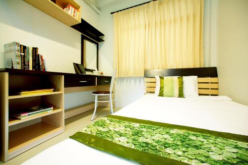 a bedroom with a bed and a book shelf at Smile Inn in Bangkok