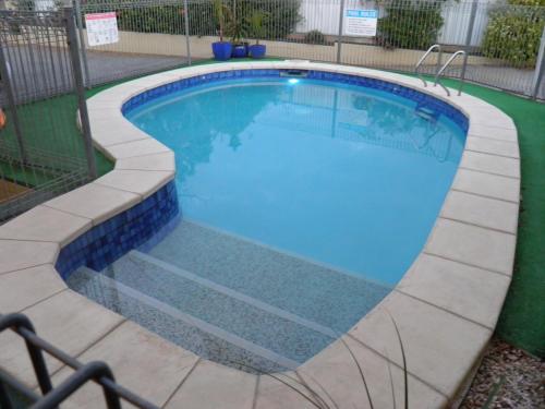 a swimming pool with blue tile around it at 7th Street Motel in Mildura