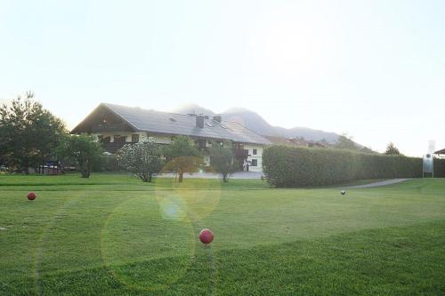 a house with red balls in the grass at DEVA Hotel-Restaurant Fischerwirt inklusive Chiemgau Card in Ruhpolding