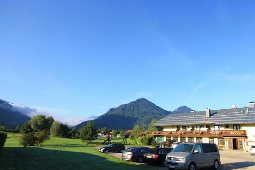 a large building with cars parked in front of it at DEVA Hotel-Restaurant Fischerwirt inklusive Chiemgau Card in Ruhpolding