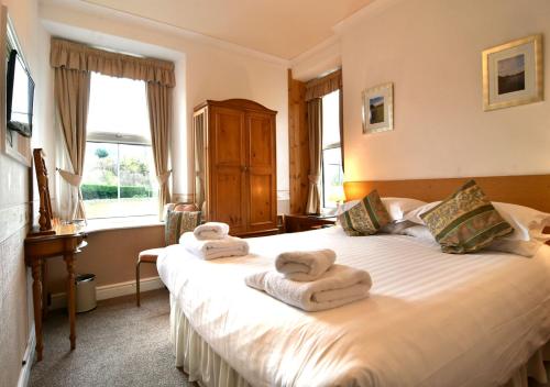 um quarto com uma cama com toalhas em Brook House Inn em Eskdale