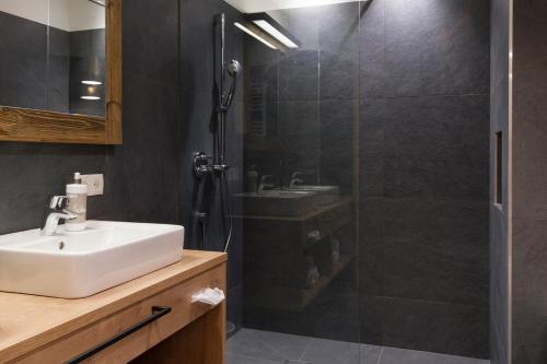 a bathroom with a sink and a shower at Sepp & Hannis Suiten im Dorf in Neustift im Stubaital