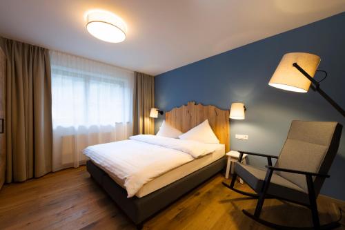 a bedroom with a bed and a desk and a chair at Sepp & Hannis Suiten im Dorf in Neustift im Stubaital