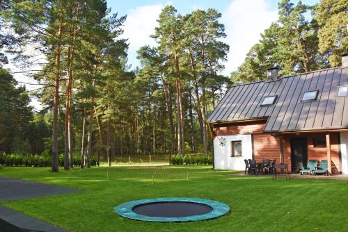 a house with a trampoline in the yard at Vacation Home Mezsargi in Pape