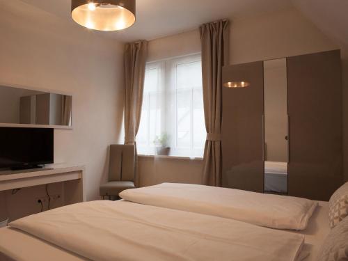 a hotel room with two beds and a window at Hotel Ravene in Cochem