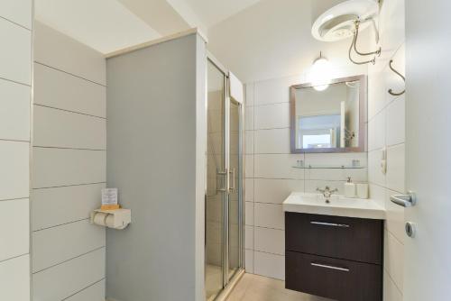 a bathroom with a shower and a sink and a mirror at City Class Accommodation in Zadar