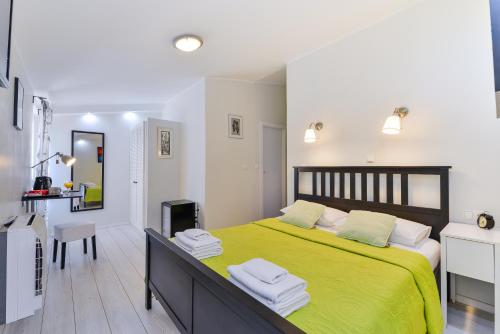 a bedroom with a large bed with a yellow blanket at City Class Accommodation in Zadar
