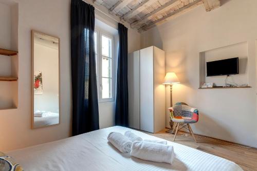フィレンツェにあるMamo Florence - Boheme Apartmentのベッドルーム(ベッド1台、椅子、テレビ付)